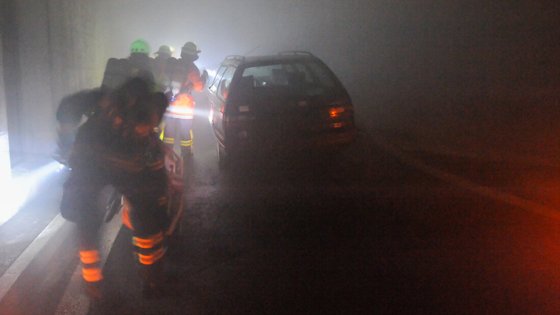 Feuerwehrangehörige üben das Absuchen von Fahrzeugen im verrauchten Tunnel