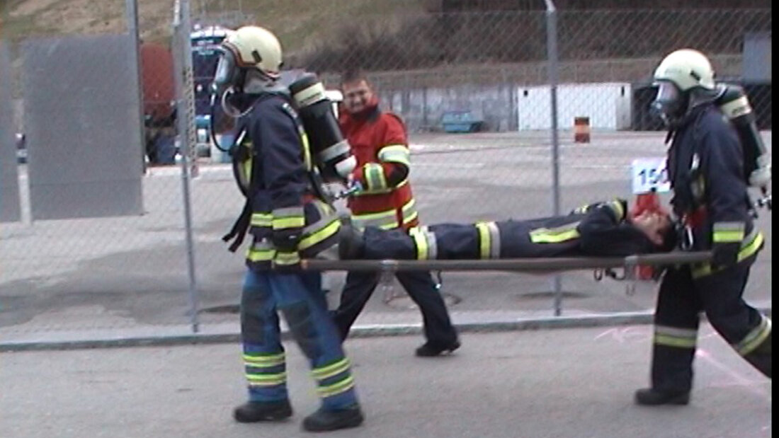 Feuerwehrangehörige tragen eine Person bei einem Transportversuch für Tunneleinsätze