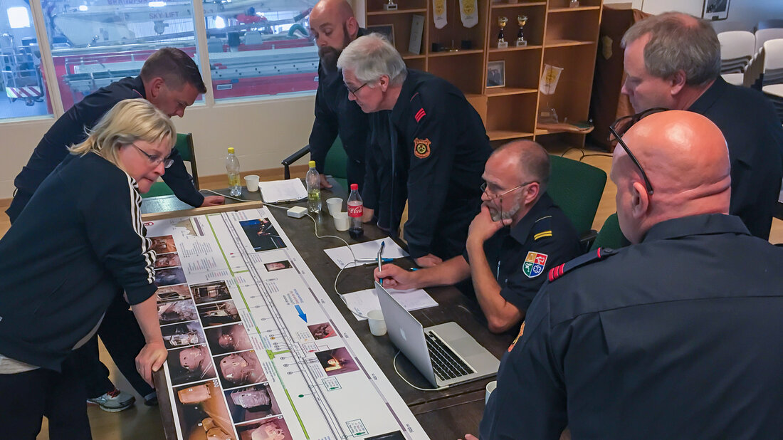 Feuerwehrangehörige bearbeiten eine Case Study zum Grossbrand im Gotthard Strassentunnel.