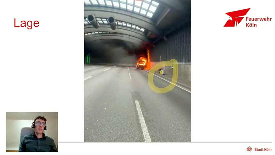 Einsatzsituation mit brennendem PKW und dem Gepäck am Fahrbahnrand