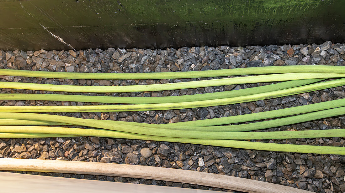 Feuerwehrschläuche exakt nebeneinander ausgelegt