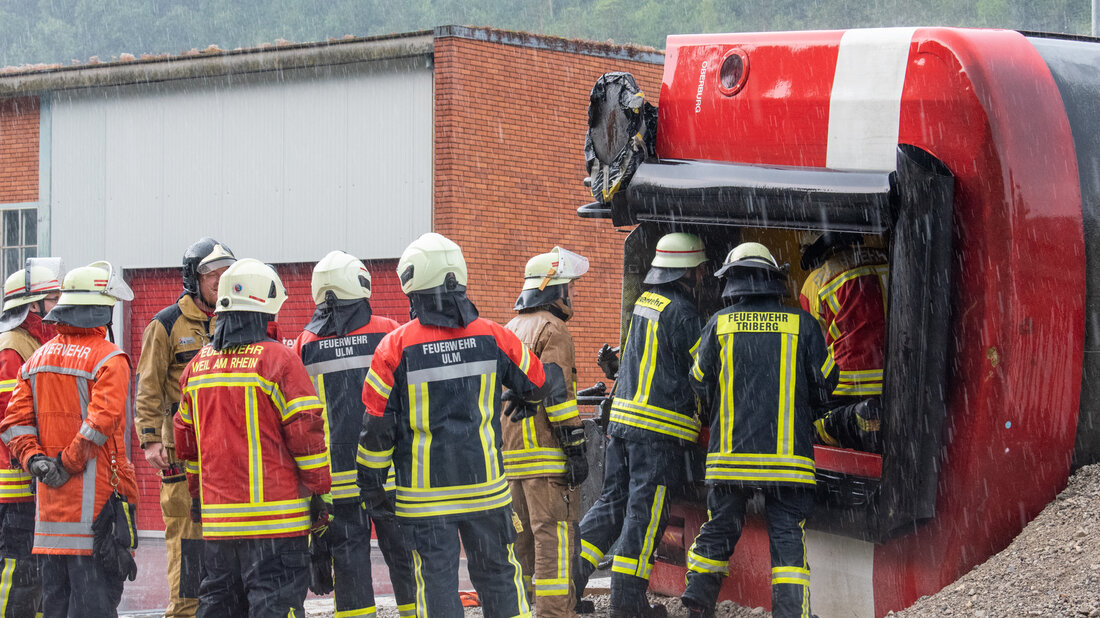 Firefighters practise rescuing a person from an overturned railway wagon.