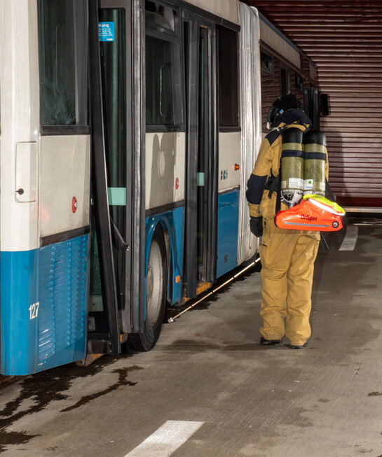 Search along bus Firefighter searches the area alongside the bus