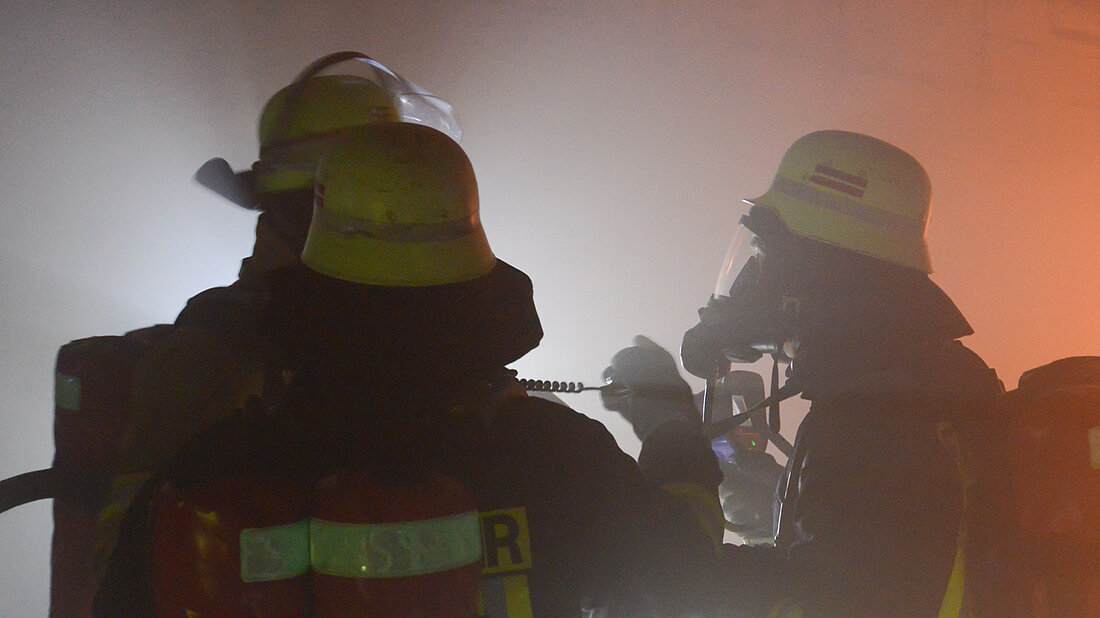 Feuerwehrangehörige kommunizieren im Tunnel