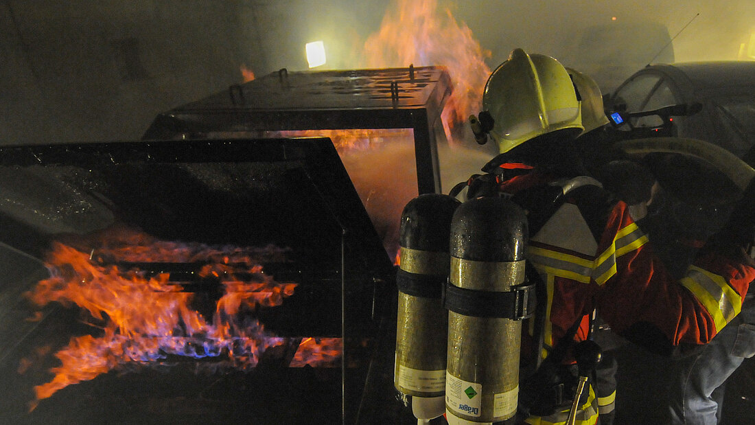 Exercice avec des installations de simulation de feu fonctionnant au gaz. Feuerwehrleute bei einer Übung mit einer brennenden PKW-Attrappe im Tunnel