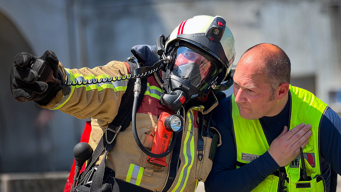Führung in der Feuerwehr Feuerwehrmann unter Atemschutz weist die Richtung
