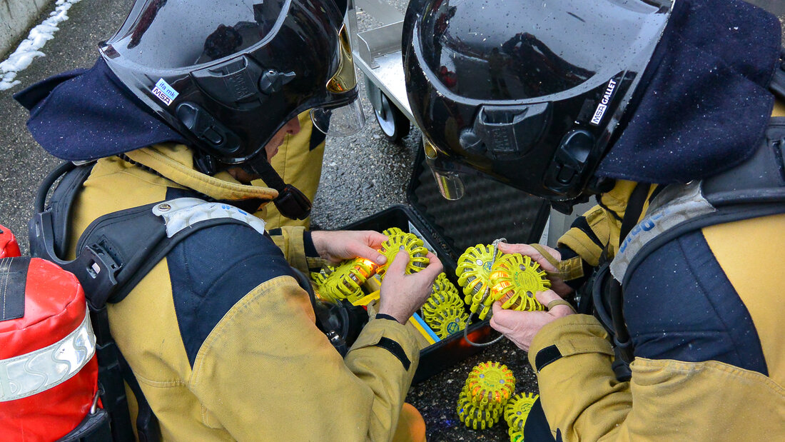 Feuerwehrangehörige aktivieren Markierleuchten für den Einsatz bei einer TunnelbrandÜbung