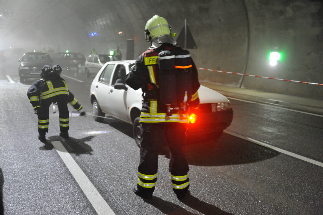 Firefighters search a tunnel tube for people.