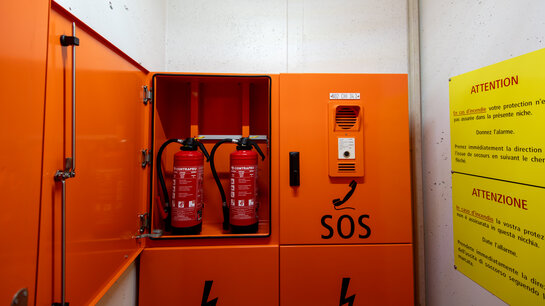 Armoire contenant des extincteurs dans une niche de secours