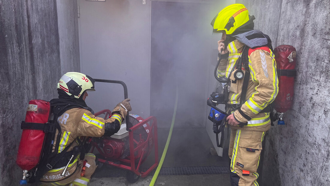 Firefighters deploy a fan at an underground car park 