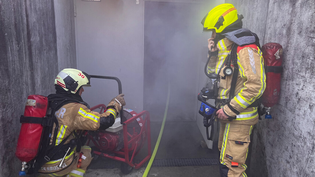 Feuerwehrangehörige setzen einen Lüfter an einer Tiefgarage ein 