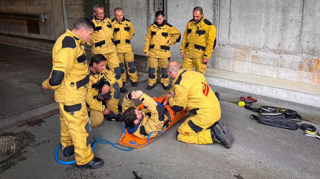 Feuerwehrangehörige üben den Transport von Personen mit einer Halbschleiftrage