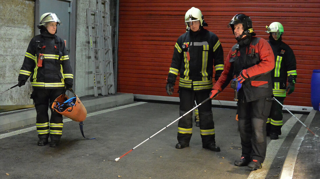 Instruction sur le travail avec le bâton de recherche. Un instructeur forme des sapeurs-pompiers à l’utilisation du bâton de re-cherche.