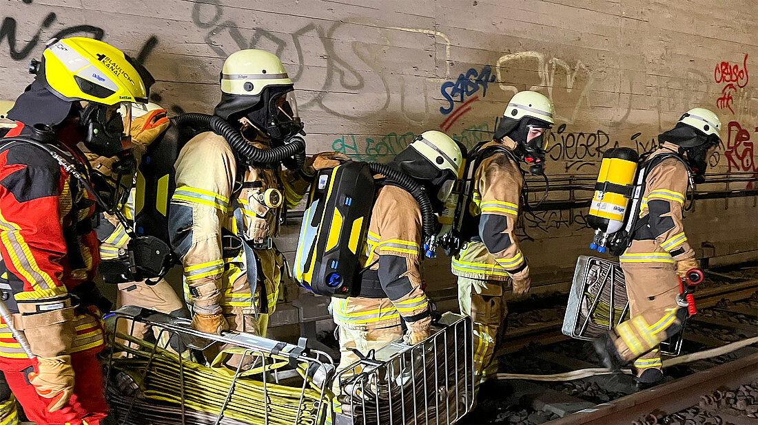 Üben am Standort Feuerwehrangehörige unter Atemschutz trainieren in ihrem Tunnel