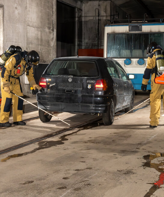 Search along car Firefighters search areas along a car.