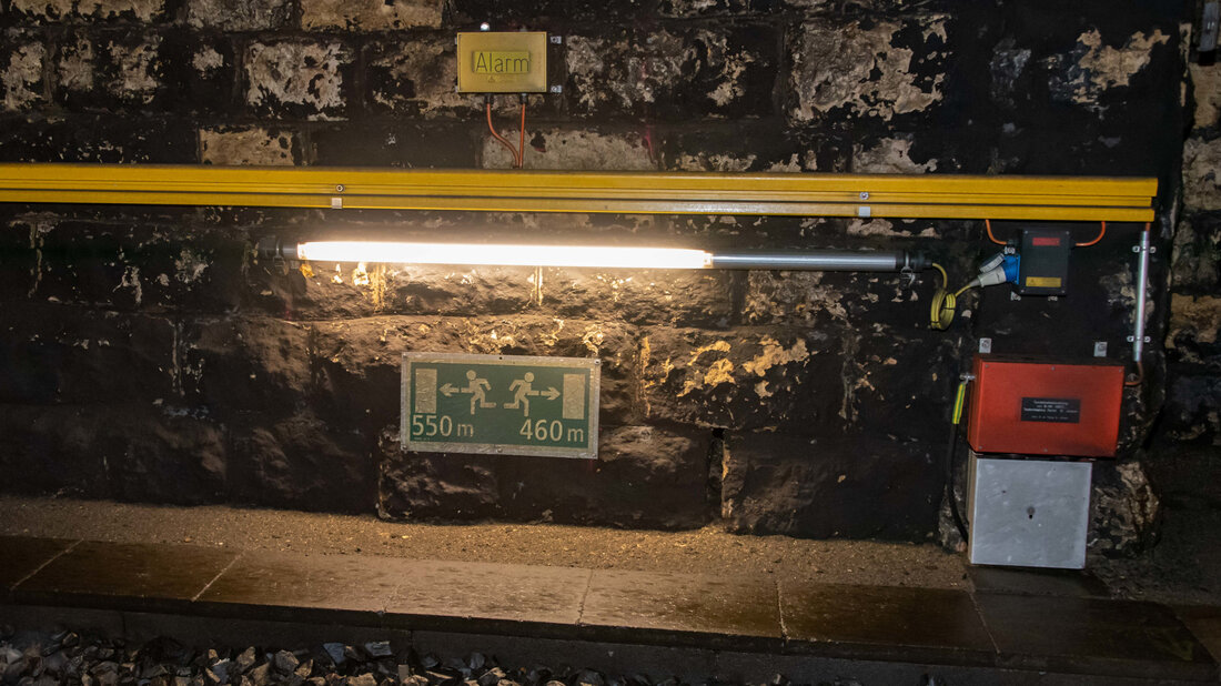 Infrastruktur im Bahntunnel Innenansicht eines Tunnels mit Handlauf und Alarmknopf