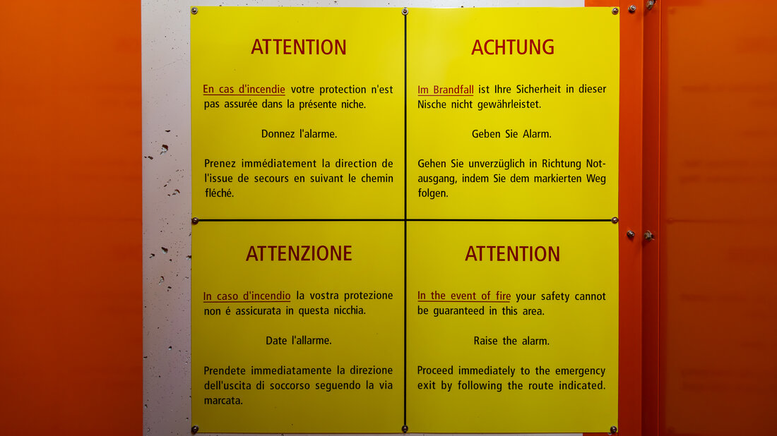 Avertissements affichés dans une niche de secours et destinés aux usagers du tunnel