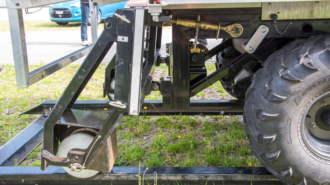 Road-rail vehicle with the rubber wheels on railway tracks and steered by a track-guiding mechanism.