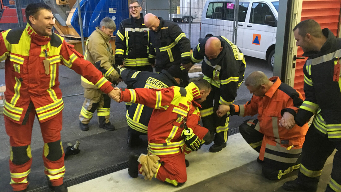 Feuerwehrangehörige trainieren das gemeinsame Lösen von Problemen in der Übung „Brandschlingenralley“